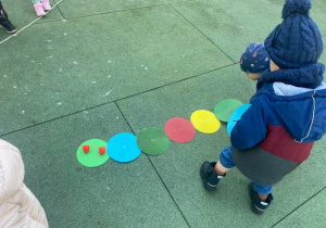Dzieci układają gąsienicę z kolorowych krążków