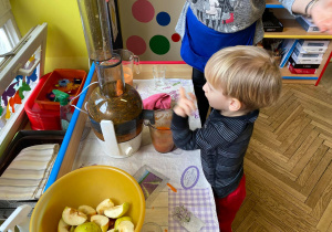 Dzieci wrzucają warzywa i owoce do sokowirówki