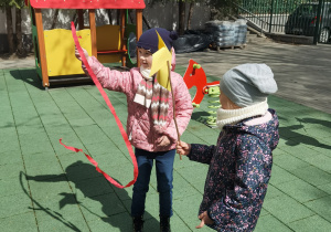 Zabawy w ogrodzie z wykorzystaniem wiatraków zrobionych przez dzieci