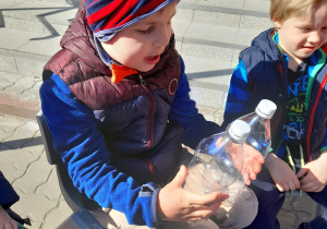Dzieci prowadzą doświadczenia z wodą - mierzą płyny.