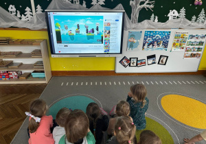 Dzieci oglądają filmik edukacyjny na temat bezpieczeństwa w Internecie i rozwiązują zagadki