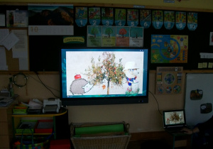Dzieci oglądają w sali film o jeżyku ogrodniku
