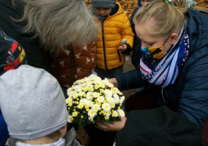 Dzieci sadzą z malutką pomocą Pani Moniki i Pani Małgosi kwiaty w doniczce, żółte chryzantemy i mrozy.