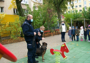 Pies policyjny pokazuje jak wykonuje komendy pani policjantki