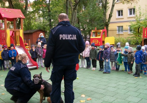 Pani Policjantka tłumaczy dzieciom dlaczego pies ma kaganiec i jest na smyczy